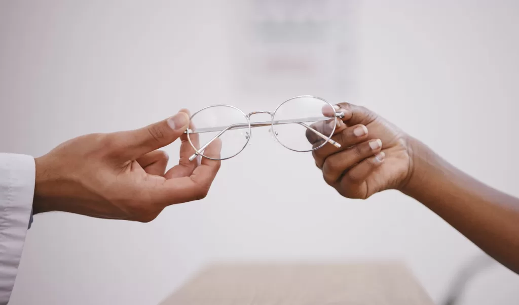 Hands holding lightweight screwless metal eyeglasses frame