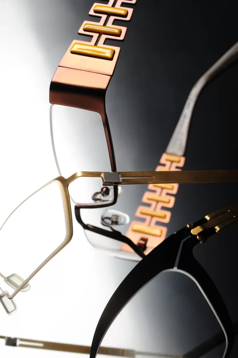 Close-up of luxury screwless metal eyeglass frames with gold temples and geometric design